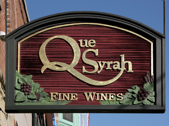 Image of the sandblasted HDU blade sign for the Que Syrah Wine Store in Old Town Chicago, IL 